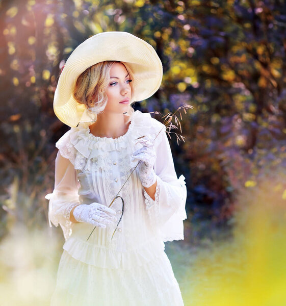 portrait of beautiful woman in victorian age dress and fancy hat walking outdoor