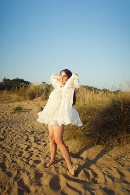 Kumsalda dans eden güzel bir kadın. Kum tepelerinde ve kumullarda.
