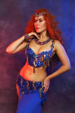 Göbek dansçısı. Mavi sutyen, kostüm, kızıl saç. Güzel sanatçı.