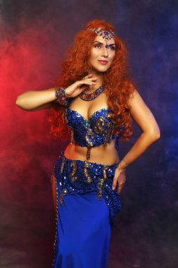 Göbek dansçısı. Mavi sutyen, kostüm, kızıl saç. Güzel sanatçı.