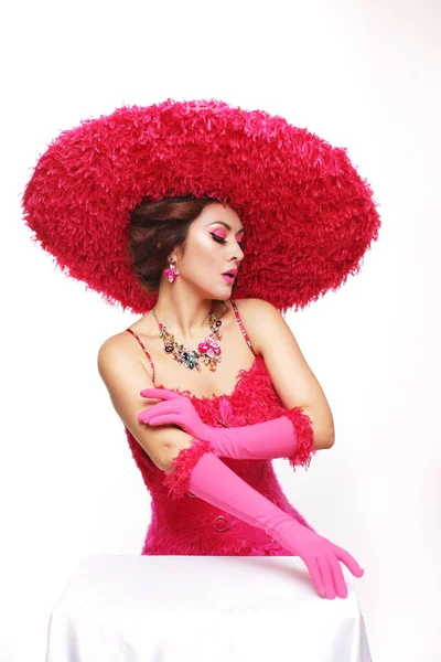 stock image Beautiful lady in pink outfit big feather hat and gloves