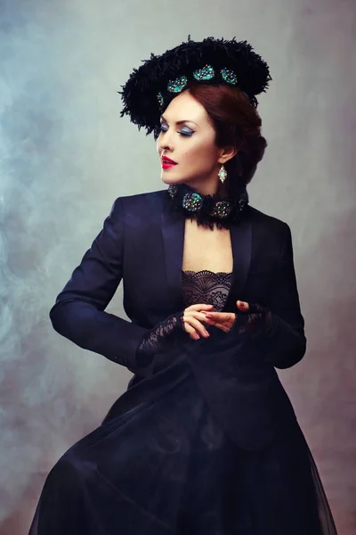 Femme fatale woman in black outfit fancy hat and chocker. Black lace romance.