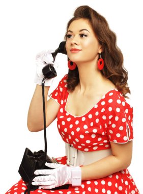 Kırmızı benekli elbise ve beyaz eldivenler giyerek eski telefondan arayan güzel kız.
