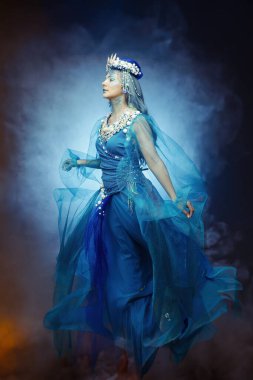 Dramatik mavi makyajı ve deniz kabuğu tacı ile büyüleyici deniz kraliçesi. Otantik fantezi sihirli ve okyanus temalarını ara