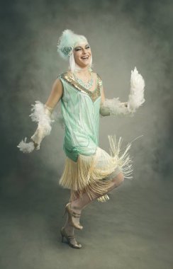 Kıvırcık bir kadın dans ediyor, elbisesiyle oynuyor, eski moda konsept.