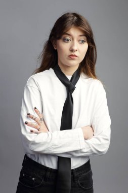 Endişeli, üzgün bir yüzü olan genç bir kadın kollarını kavuşturmuş duruyor. Anksiyete, pişmanlık, kötü haber, depresyon, zihinsel sağlık sorunları ve işyeri stresi veya başarısızlık için güçlü bir kavram.