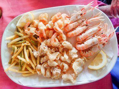 Restoranda Akdeniz balığı atıştırması. Bir İtalyan restoranında taze balık tabağı. Kabuklular ve yumuşakçalar