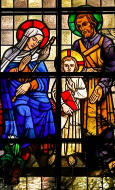 Kalety, Poland, January 1, 2023: Stained glass windows in the church of St. Franciszek in Miotek, seen from the outside in the evening.  Holy family, Jesus Joseph and Mary.