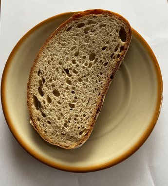 Yakından bakıldığında, yağsız bir ekmek dilimi tabakta duruyor.