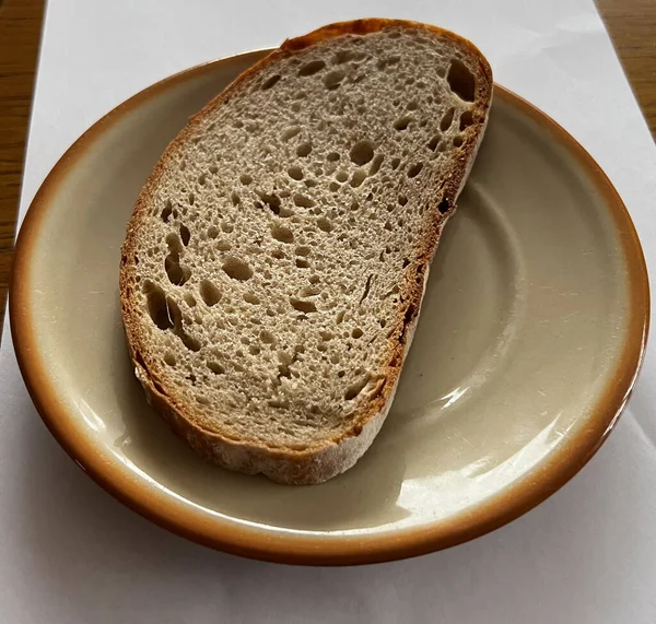 Eine Ungeputzte Scheibe Brot Die Großaufnahme Auf Einem Fayence Teller — Stockfoto