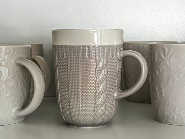 Rafta duran boş tek renk porselen bardaklar..