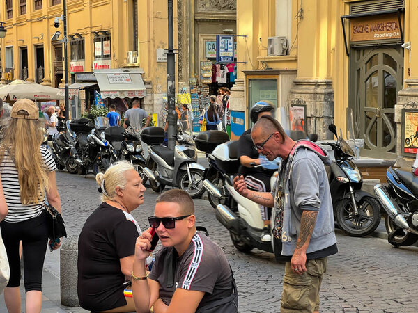 Неаполь, Италия, 27 сентября 2023 года: Узкая улица в старой части города, заполненная большим количеством припаркованных мотоциклов, скутеров и мопедов.
