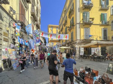 Napoli, İtalya, 28 Eylül 2023: Napoli, İtalya 'da kalabalık dar sokaklar, çoğunlukla turist dolu, ama aynı zamanda iki tekerlekli ve arabalı. Bir sürü reklam, futbol temalı bayraklar ve çeşitli mağazalar ve barlar.