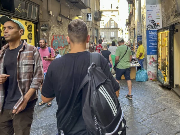 Meapol, İtalya, 28 Eylül 2023: Napoli, İtalya 'da kalabalık dar sokaklar, çoğunlukla turist dolu, ama aynı zamanda iki tekerlekli ve arabalı. Bir sürü reklam, futbol temalı bayraklar ve çeşitli mağazalar ve barlar.