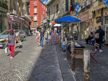 Napoli, İtalya, 28 Eylül 2023: Napoli, İtalya 'daki dar sokaklar. Bir sürü insan, tezgah, barlardan sayısız masa, turistler, halk, iki tekerlekli, trafik ve gürültü.
