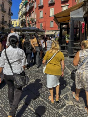 Napoli, İtalya, 28 Eylül 2023: Napoli, İtalya 'daki dar sokaklar. Bir sürü insan, tezgah, barlardan sayısız masa, turistler, halk, iki tekerlekli, trafik ve gürültü.
