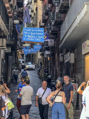 Napoli, İtalya, 27 Eylül 2023: Şehrin eski kesiminde turist ve yerlilerle dolu bir sokak renkli bir manzara yaratıyor.