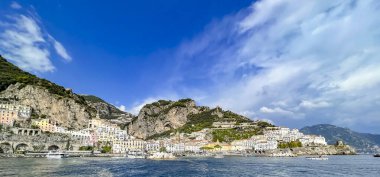 Amalfi, Campania, İtalya 'daki dağların yamaçlarındaki güzel binaların denizinden manzarayı seyret..