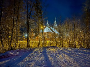 Polonya 'nın Koszecin kentindeki Aziz Trinity Kilisesi' ne adanmış eski ahşap kilise. Geceleri görünüm.