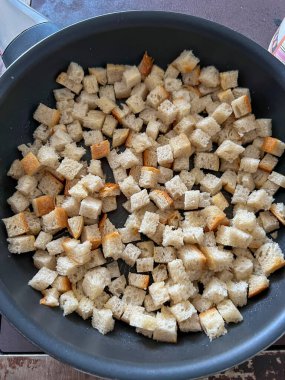 Dilimlenmiş ekmek parçaları tereyağı ve sarımsaklı bir tavada kızartılır ve balkabağı kreması için kıtır ekmek böyle yapılır..