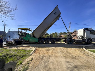 Kalety, Polonya, 12 Nisan 2024: Yeni bir sokak yüzeyi inşaatı. Uzman bir makineyle asfalt tabakası sermek.