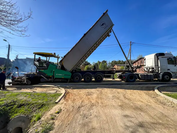 Stock image Kalety, Poland, April 12, 2024: Construction of a new street surface. Laying a layer of asphalt with a specialized machine.