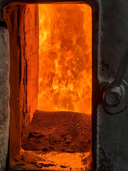 stock image Fire in the combustion chamber of a coal-fired stoker boiler visible through the window.