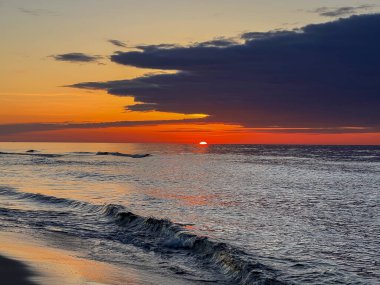 Mayıs ayı başlarında Polonya 'nın Jastrzebia Gora bölgesindeki Baltık Denizi sahilinde gün batımı.