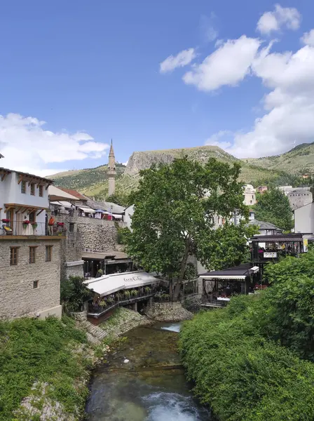 MOSTAR, BOSNIA VE HERZEGOVINA, 11 Haziran 2024: Bosna Hersek 'in Mostar kentinde turistleri bekleyen restoranları ve kafeleri olan eski binalar.