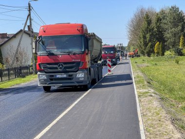 Kalety, Polonya, 30 Nisan 2024: Modernize yol ve kaldırımın son asfalt tabakasını sermek. Asfalt ve yol silindirleri döşeyen bir makinenin işletimi.