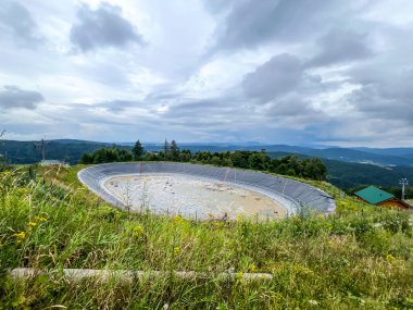 A tank prepared to hold water used later, among other things, to produce artificial snow and to lower ski slopes in the area of the Jaworzyna Krynicka mountain shelter, Poland clipart