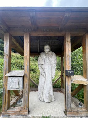 Krynica Zdroj, Poland, August 5, 2024: Monument, wooden sculpture of St. John Paul II near the mountain shelter on Jaworzyna Krynicka in Krynica Zdroj, Poland. clipart