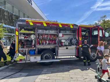 Krynica, Poland, August 4, 2024: Presentation of equipment from a fire truck to tourists on the promenade in Krynica, Poland. clipart