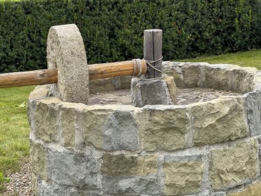 Polonya 'nın Muszyna kentindeki İncil Bahçesi' nde sunulan zeytin yağını değirmen taşı ve zeytinyağı sıkıyor..