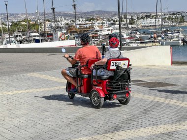 Paphos, Kıbrıs, 13 Ekim 2024: Paphos, Kıbrıs. Limandaki iskeleye demirli yatlar, küçük gemiler ve çeşitli liman ekipmanları. Üç tekerlekli bir araç..