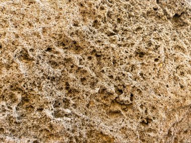 Close-up of sandstone rock, washed by weathering and water, as a background. clipart