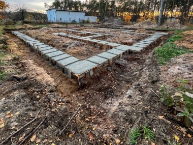 Ağaçlar arasında tek bir aile kuruluşu inşa etmek için vakıf şeritleri. Beton, eski tahtalardan yapılan resmi kaldırmadan önce yeni döküldü..
