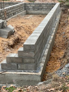 Çelik çubuklarla güçlendirilmiş beton zemindeki dört katmanlı beton bloklardan oluşan tek bir aile evinin temellerinin inşası.