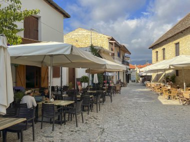 Omodos, Kıbrıs, 16 Ekim 2024: Kıbrıs 'ın eski Omodos kenti. Bölgesel hediyelik eşya, sanat ve zanaat satan dükkanlarla dolu dar sokaklar, kafeler, barlar, restoranlar.