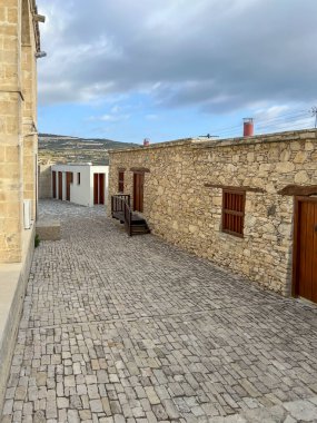 The old town of Omodos in Cyprus with historic buildings, narrow streets with shops focused on selling regional souvenirs, arts and crafts. clipart