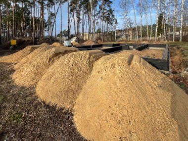Kum, inşaat halindeki tek bir aile evinin temellerini örtmek için hazırlandı..