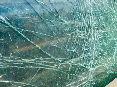 Arka plan olarak henüz parçalanmamış kırık bir araba camı..