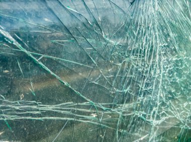 Arka plan olarak henüz parçalanmamış kırık bir araba camı..