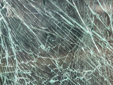 Arka plan olarak henüz parçalanmamış kırık bir araba camı..