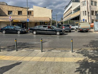 Limasol, Kıbrıs, 18 Ekim 2024: Kıbrıs Rum Kesimi 'nin Limasol kentinde bir sokakta üç sıra koltuklu bir taksi, siyah bir Mercedes gerilmiş limuzin..