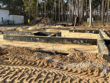 Tek bir aile evinin temellerini kumla kaplıyor ve temellerin içindeki alanı kumla dolduruyor..