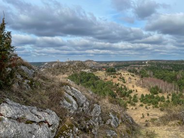 Polonya 'nın Krakow-Czestochwa tepesindeki Czestochowa yakınlarındaki Olsztyn' deki ortaçağ şatosunun kalıntılarına doğru Biaklo Dağı 'ndan manzara.