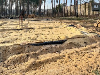 Tek bir aile evinin temellerini kumla kaplıyor ve temellerin içindeki alanı kumla dolduruyor..