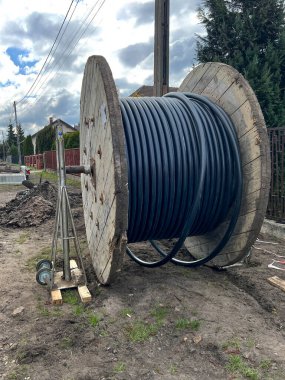 Bir yeraltı elektrik ağı inşa edilirken büyük bir varilin üzerinde kablo..