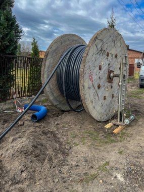 Bir yeraltı elektrik ağı inşa edilirken büyük bir varilin üzerinde kablo..